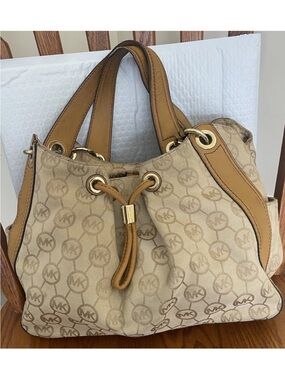 Michael Kors Beige Monogram Drawstring Shoulder Bag with Tan Trim needs cleaning